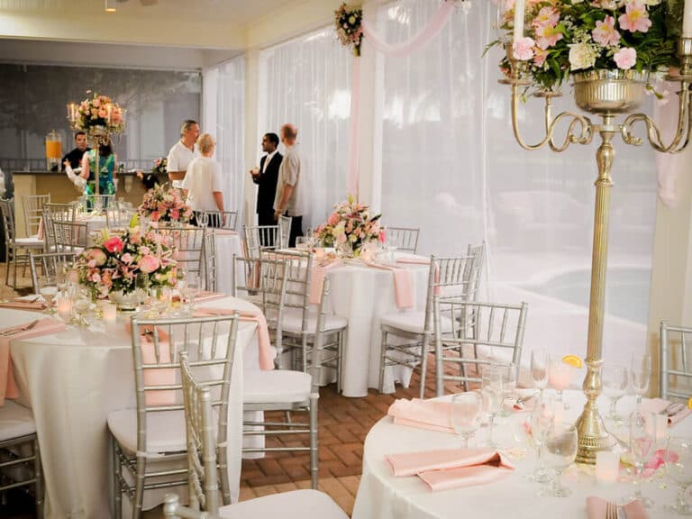 Wedding reception set up inside a screened and draped outdoor event space